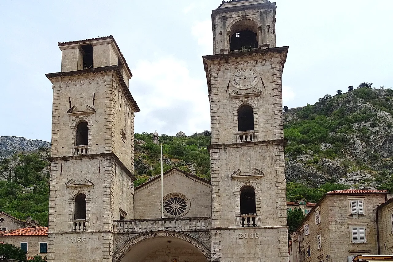 Die beiden Glockentürme und die Fassade der Kathedrale St. Tryphon in Kotor, dahinter der Berghang