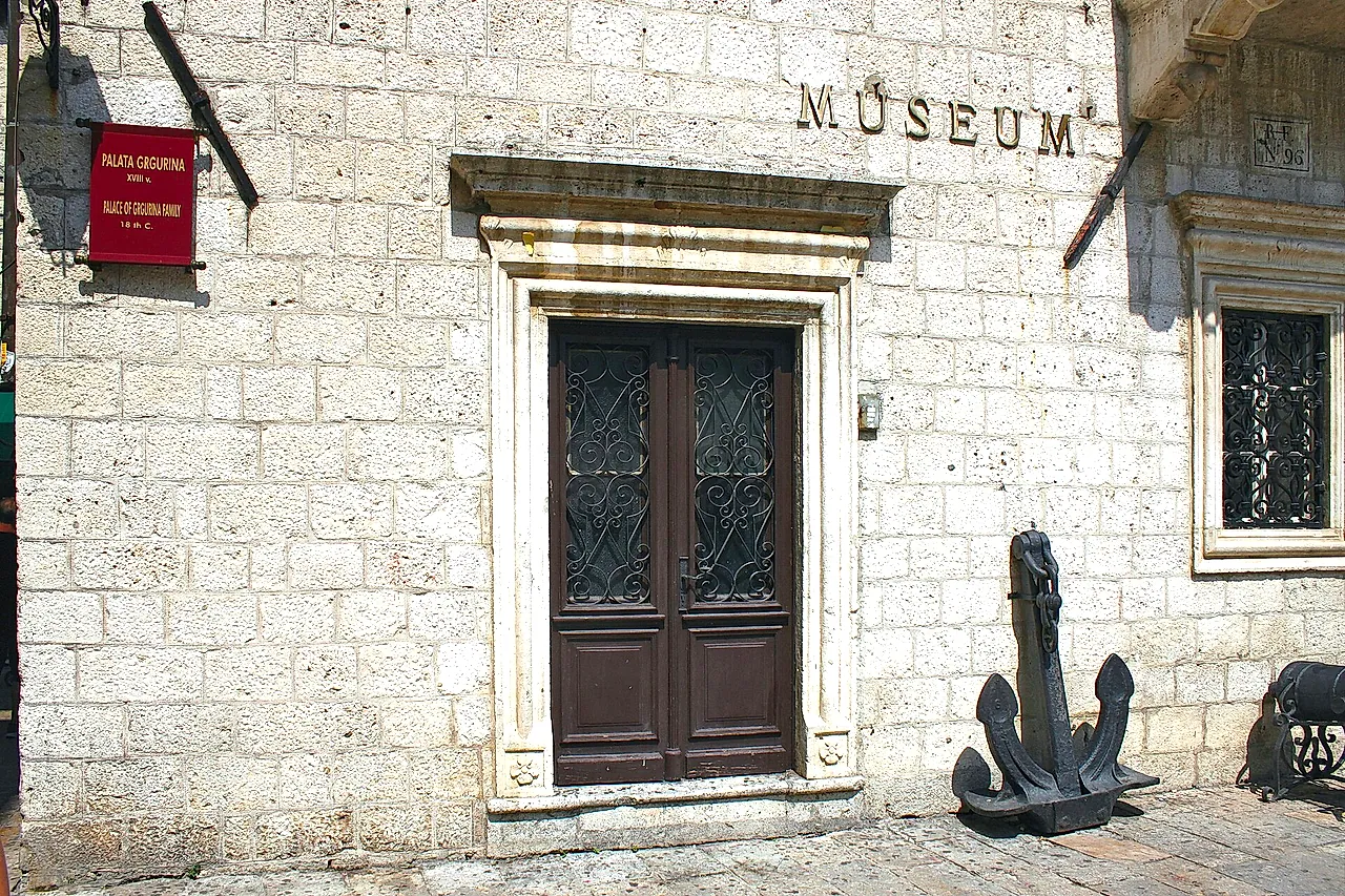 Das Portal des Palastes Grgurina, Sitz des Seefahrtsmuseums von Kotor, mit einem Anker neben der Tür